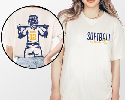 A woman wearing a white t-shirt with a graphic of a female baseball player and the text "SOFTBALL aunt" printed on it.